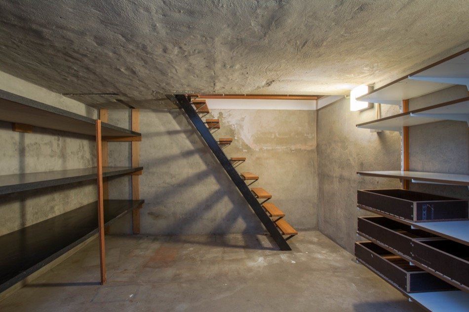 an empty basement with shelves and stairs .