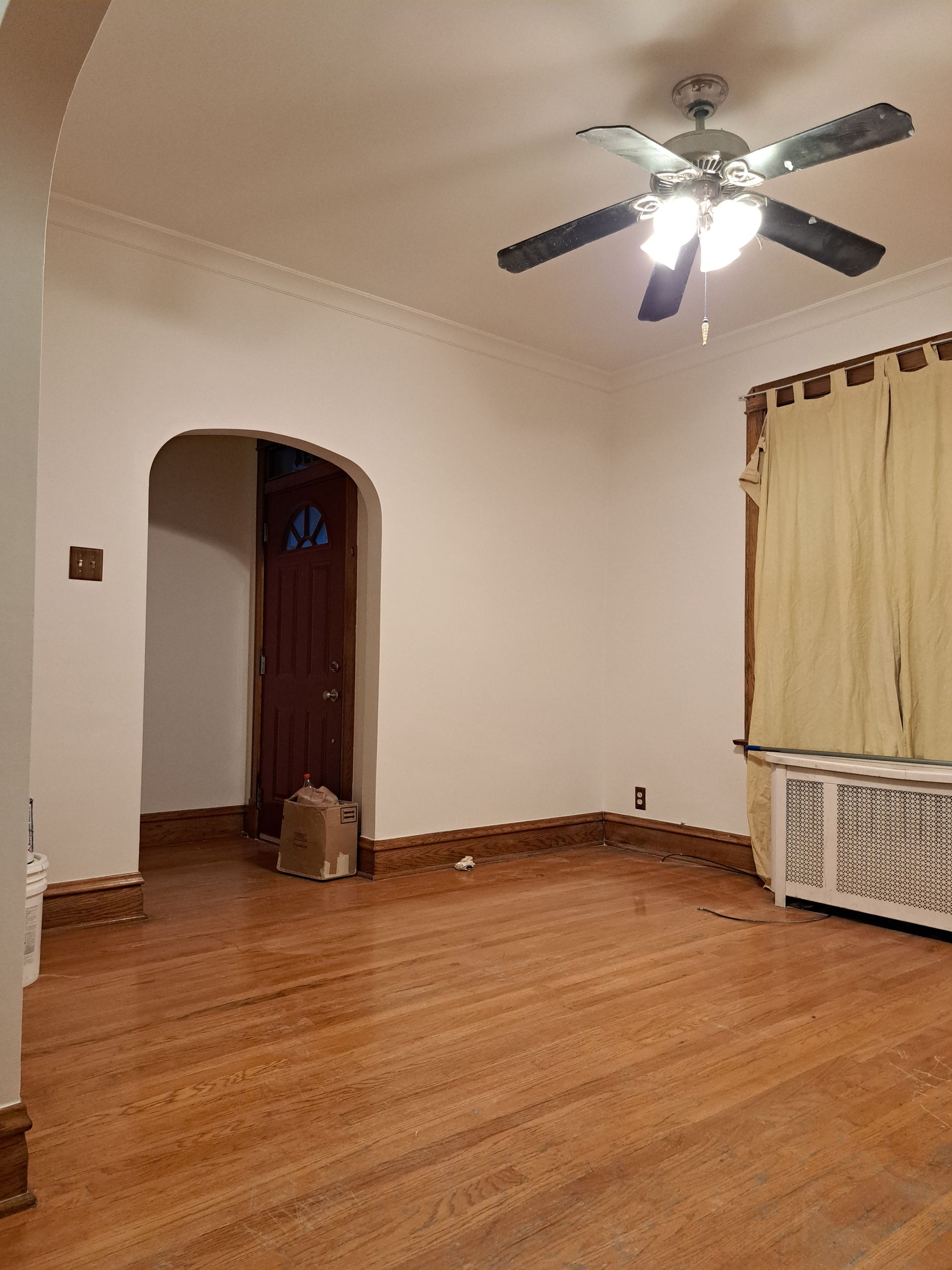 an empty room with a wooden floor and a ladder .