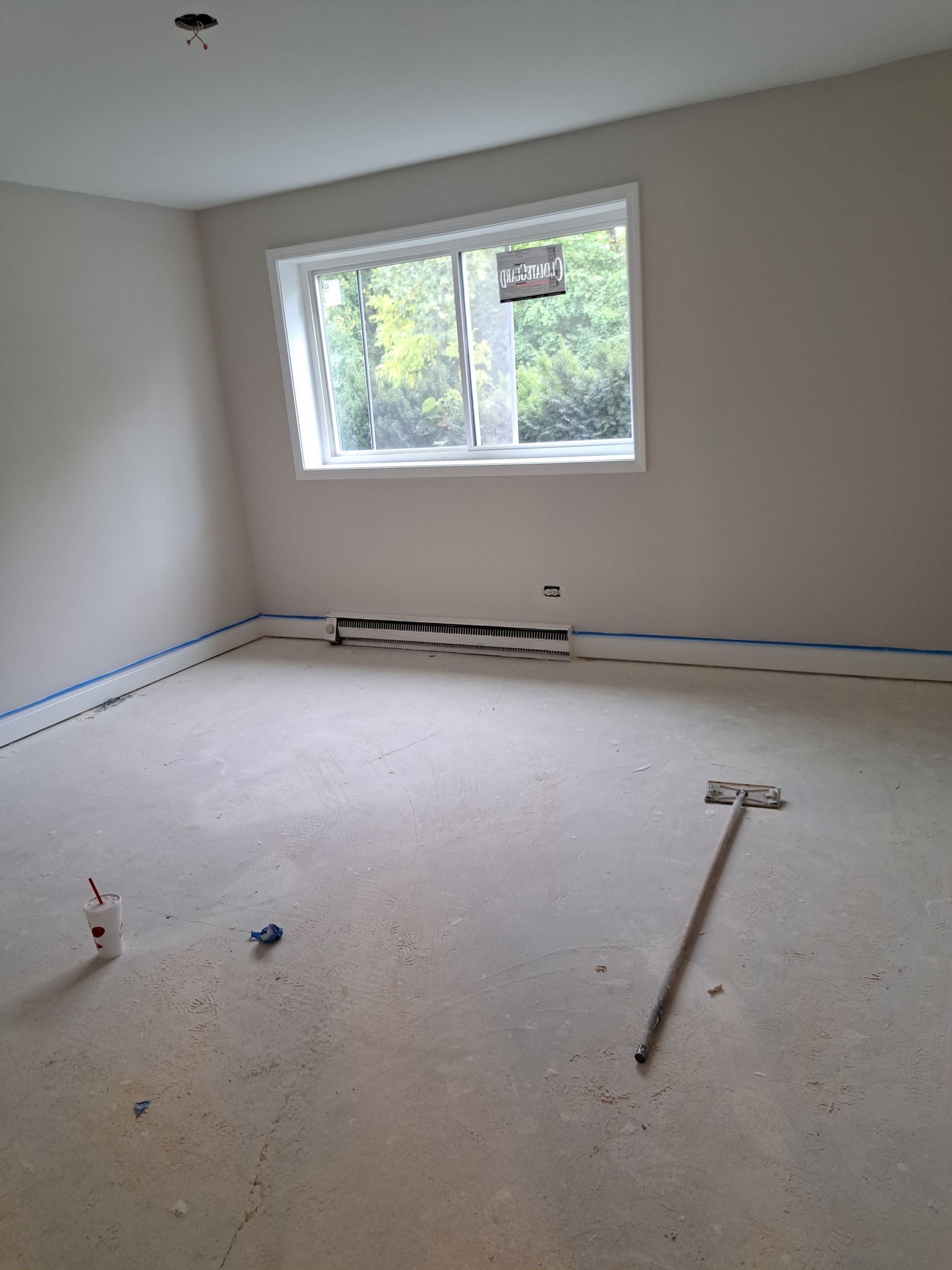 a man is laying tiles on the floor with a trowel .