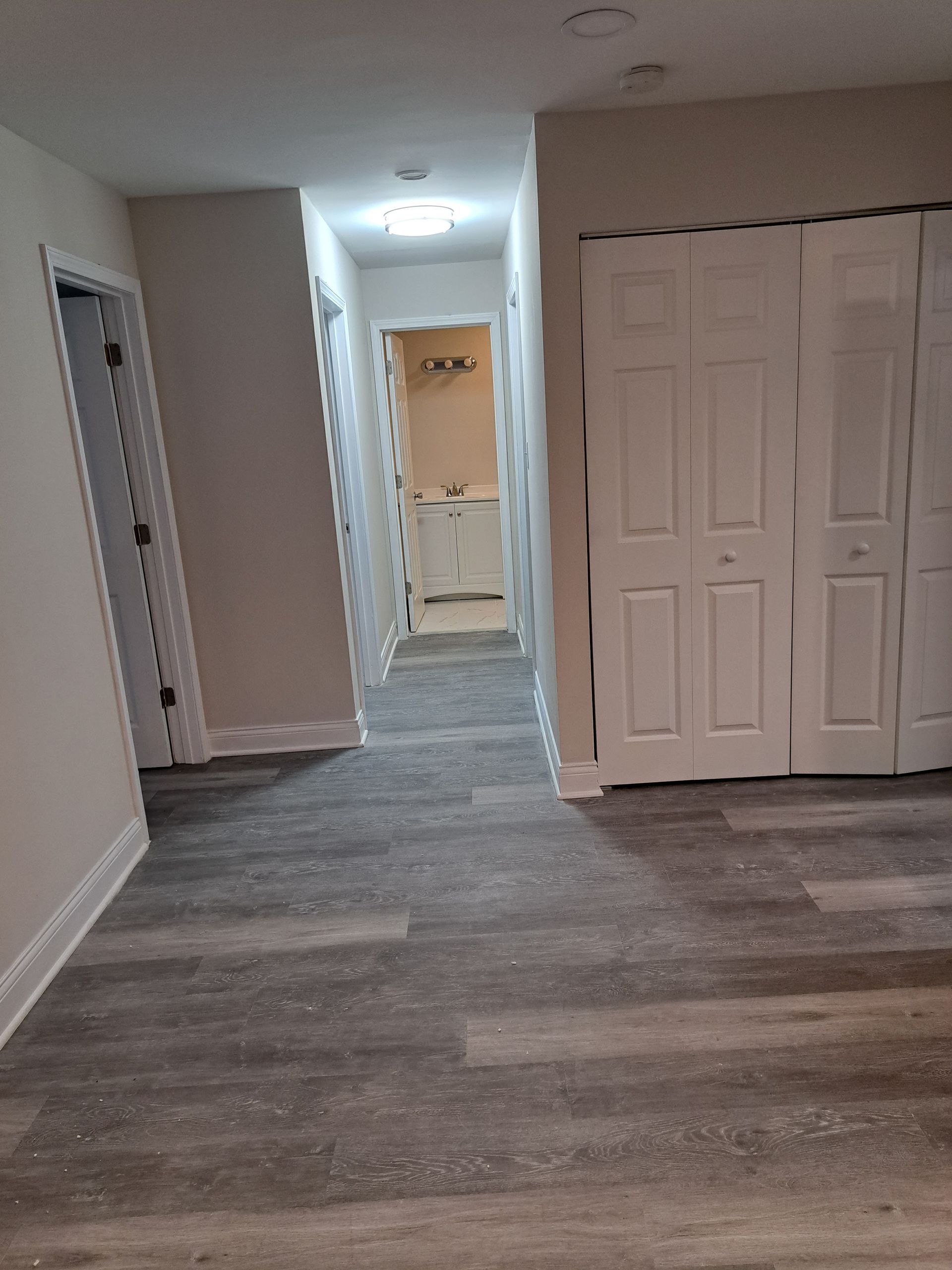 an empty room with a wooden floor and a ladder .
