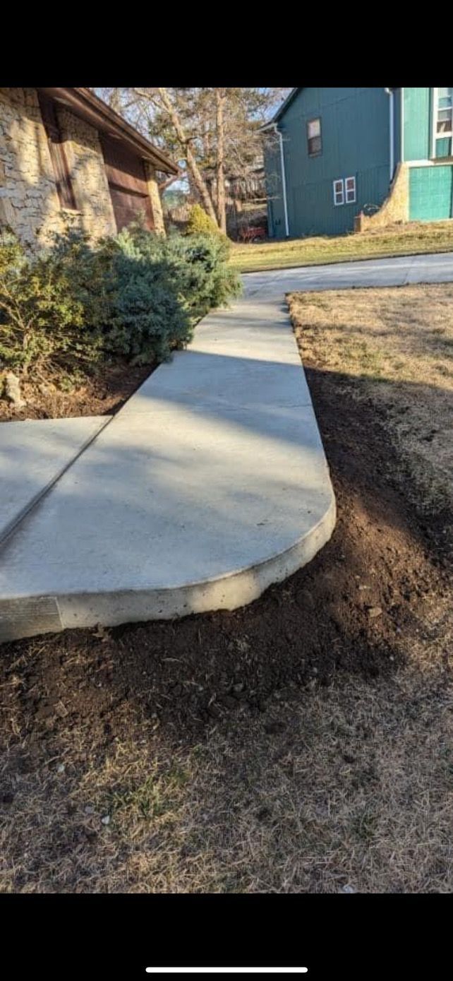 A concrete sidewalk is being built in front of a house.