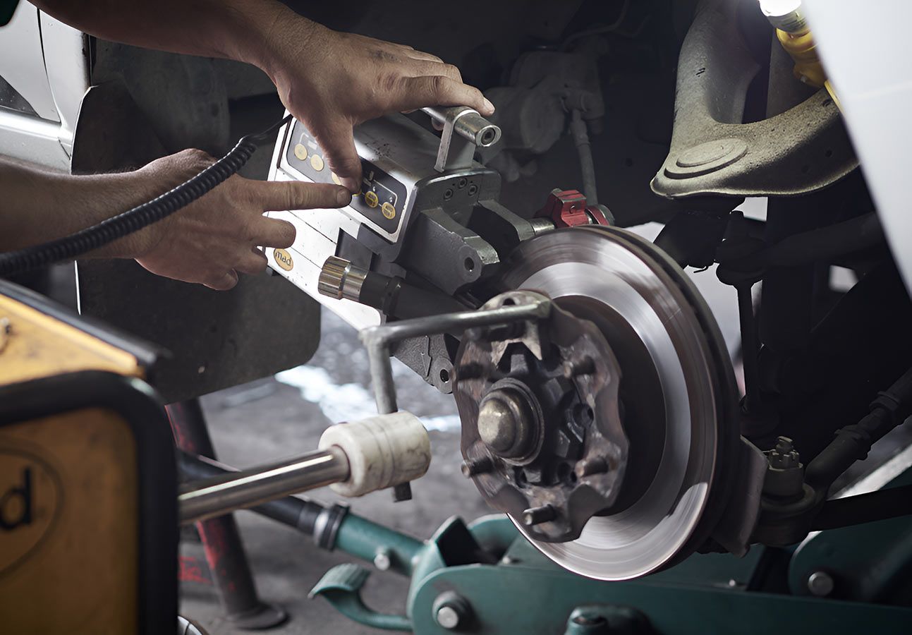 A Man is Working on a Car in a Garage — Cairns Mechanical Workshop In Bungalow, QLD