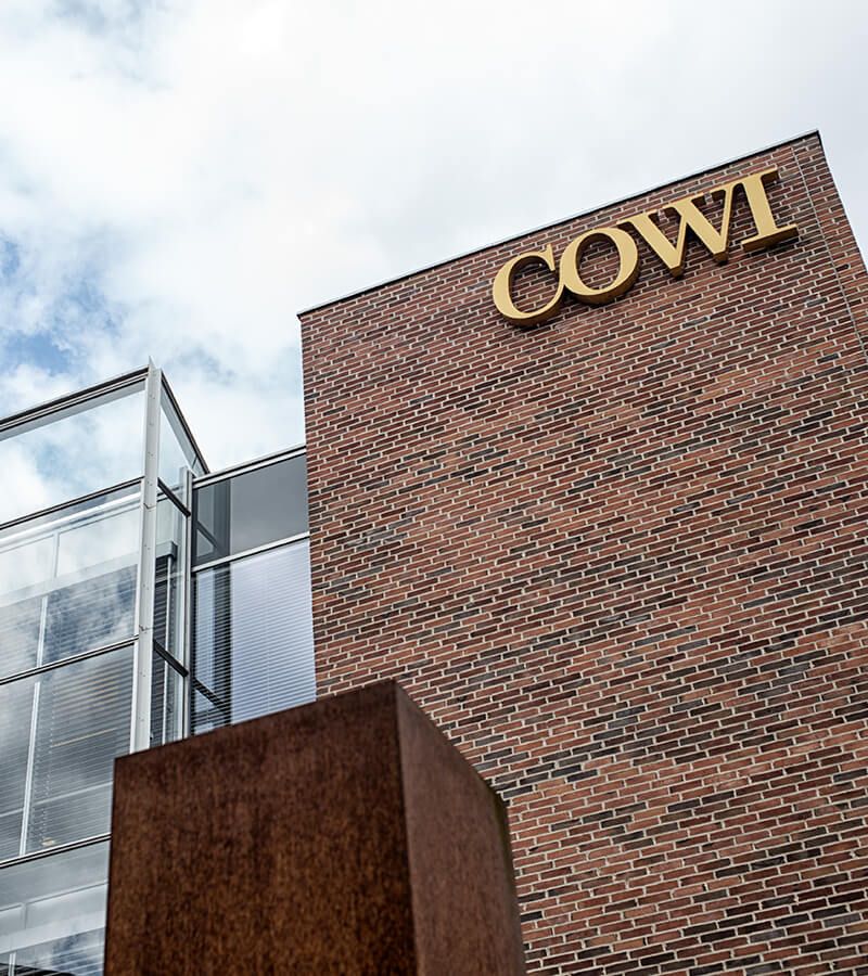 En murstensbygning med cowi skrevet på