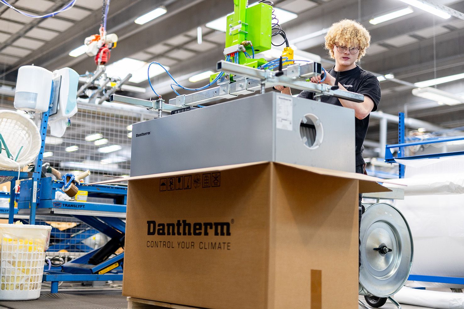 En mand arbejder på en maskine på en fabrik.