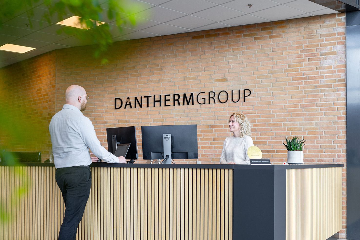 En mand og en kvinde står ved en reception på et kontor.