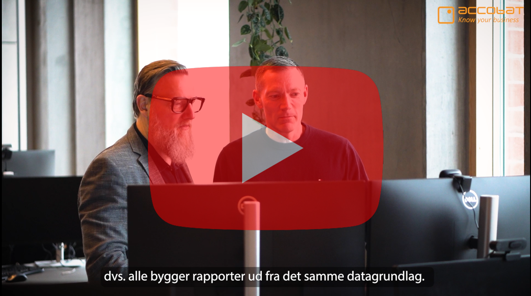To mænd sidder foran en computerskærm.