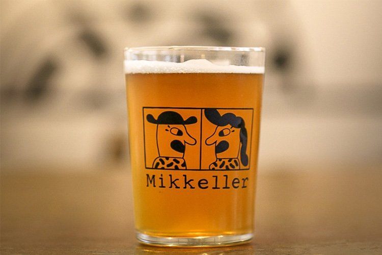 et glas øl med navnet mikkeller på