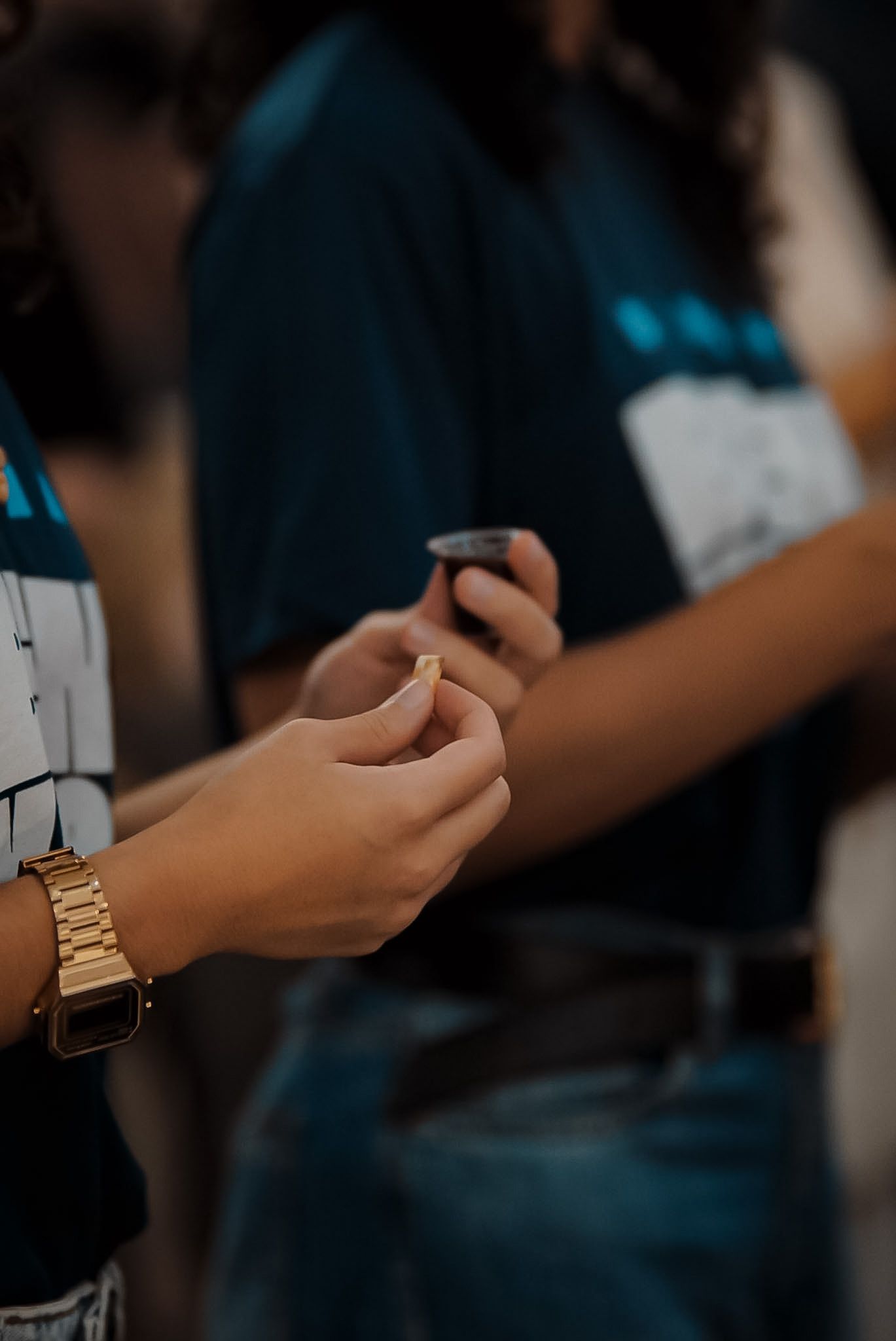 Participantes seguram pequenos cálices durante a Ceia na IPNOVA