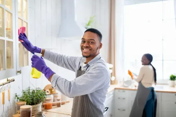 A man cleaning a home kitchen as part of regular housekeeping
