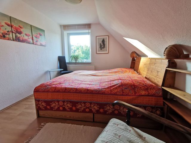Schlafzimmer 1 mit Blick über großes Doppelbett zum Fenster