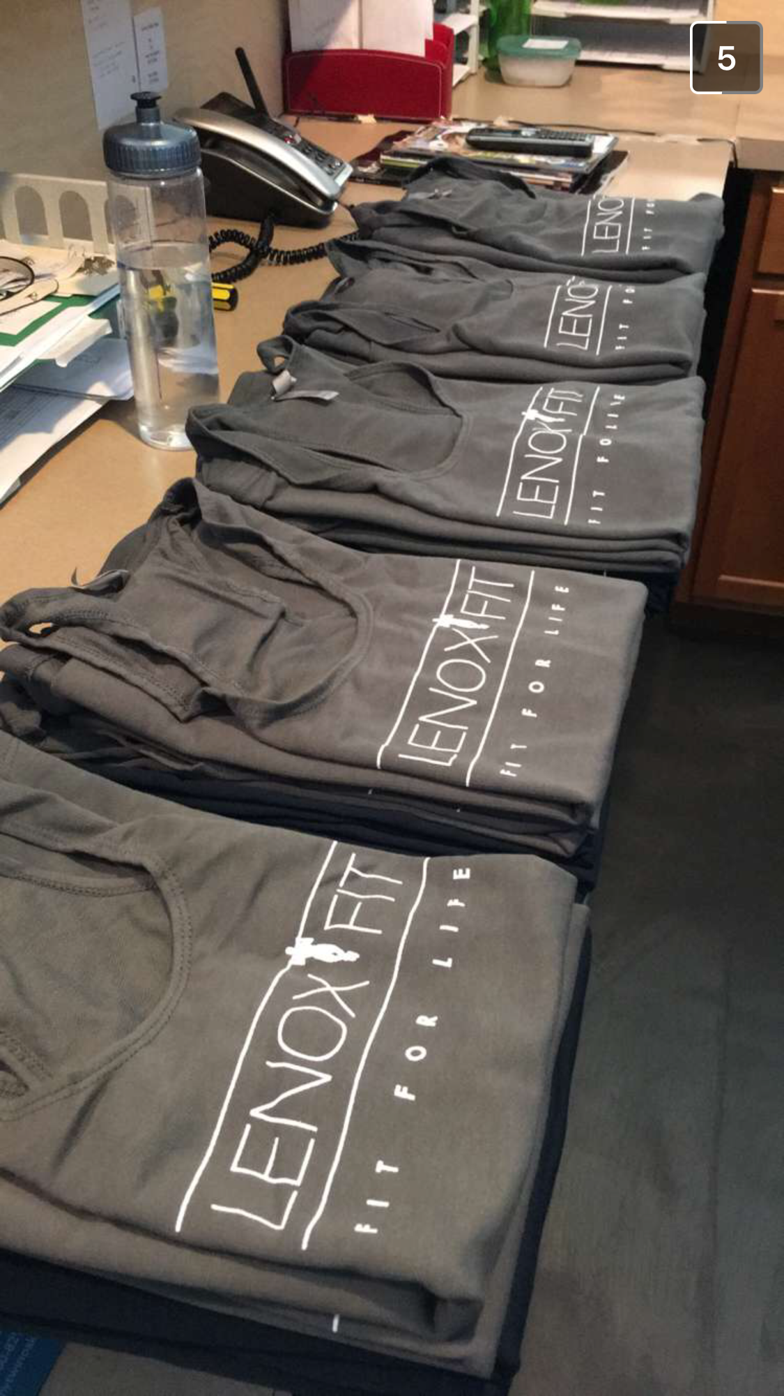 A stack of folded grey tank tops with 