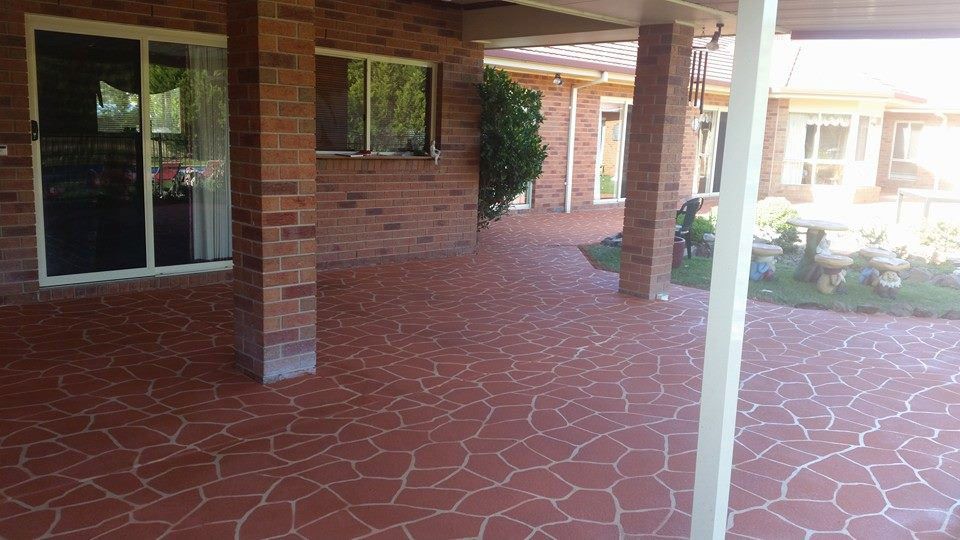 A Brick House With A Covered Patio And A Sliding Glass Door — Custom Concrete Finishes In Albury, NSW