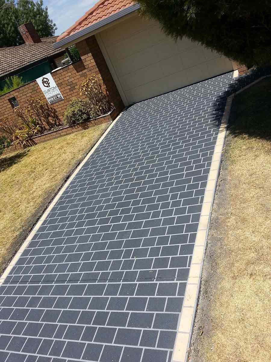 A Brick Walkway Leading To A Garage Next To A House — Custom Concrete Finishes In Thurgoona, NSW