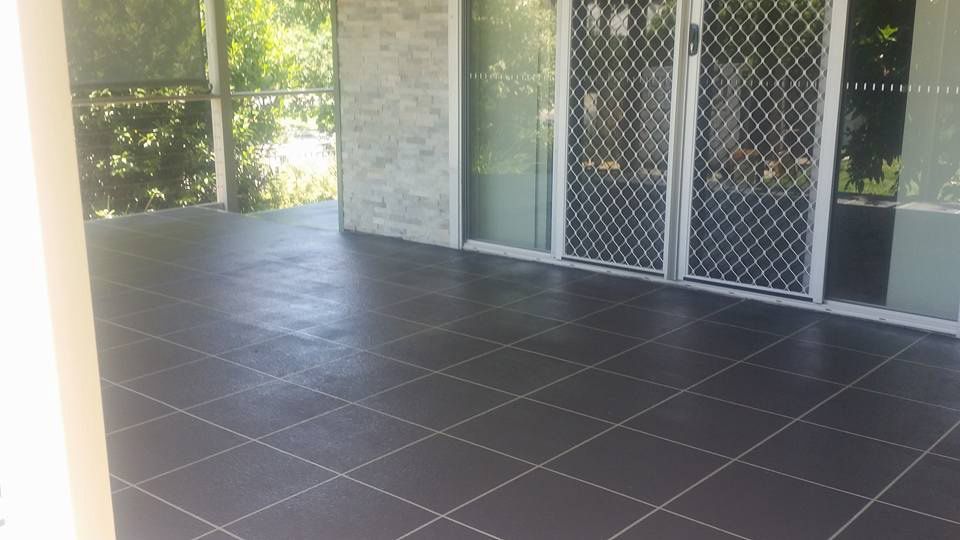 A Patio With A Black Tile Floor And Sliding Glass Doors — Custom Concrete Finishes In Wodonga, NSW