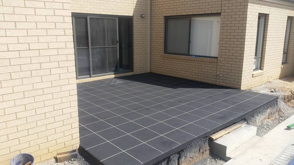 A Brick Building With A Patio In Front Of It — Custom Concrete Finishes In Wodonga, NSW