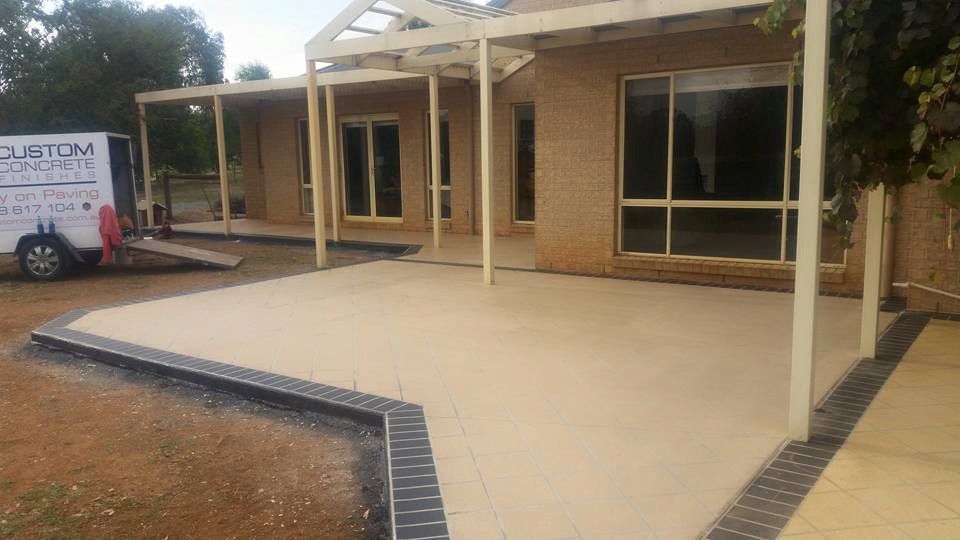 A Concrete Patio Is Being Built In Front Of A House — Custom Concrete Finishes In Killara, NSW