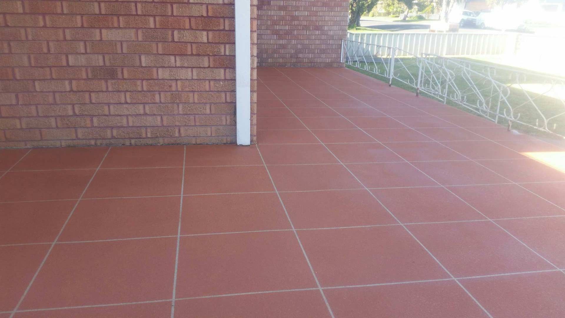 A Brick Wall With A Tiled Floor In Front Of It — Custom Concrete Finishes In Thurgoona, NSW
