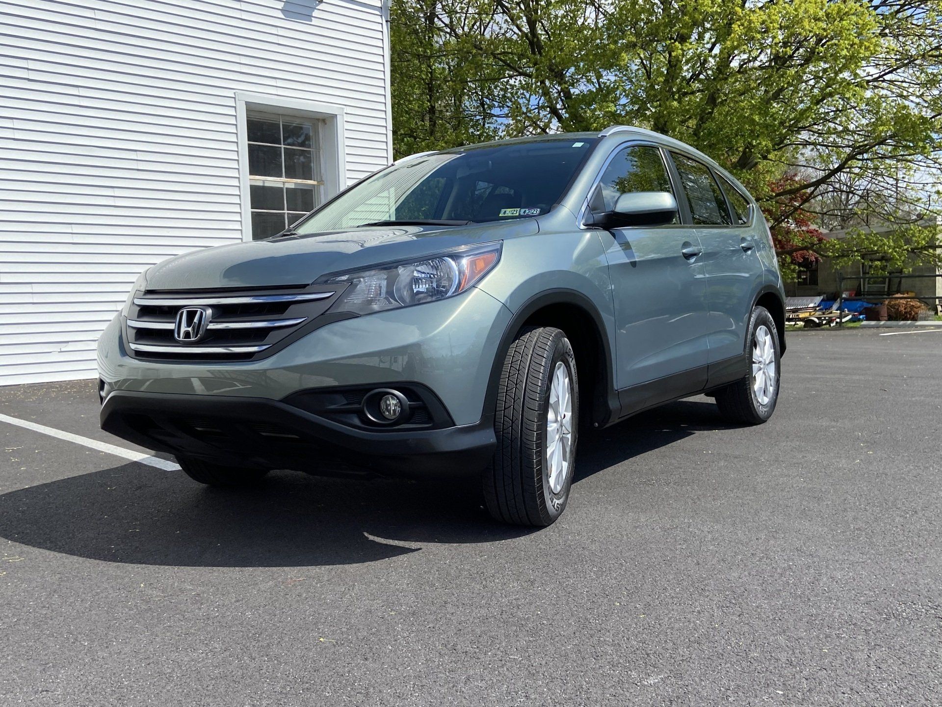 A gray honda cr v is parked in a parking lot in front of a white building.
