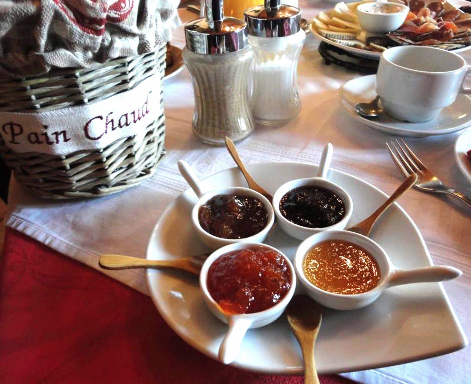 Taula d'esmorzar parada amb melmelades, pa i condiments. Cal Serni