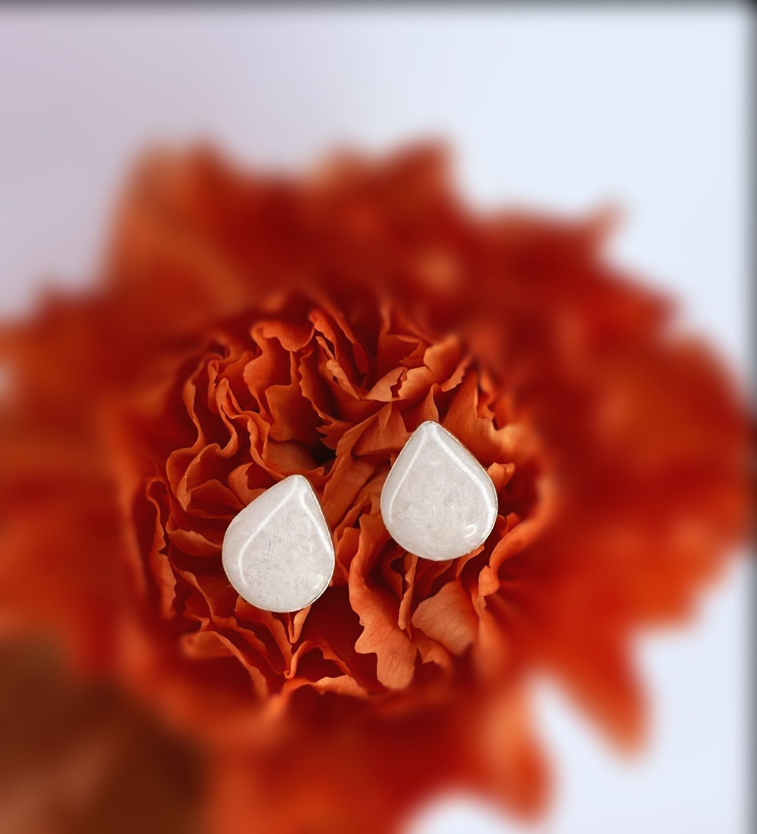 Two white egg-shaped objects on a beige surface against a blurred background