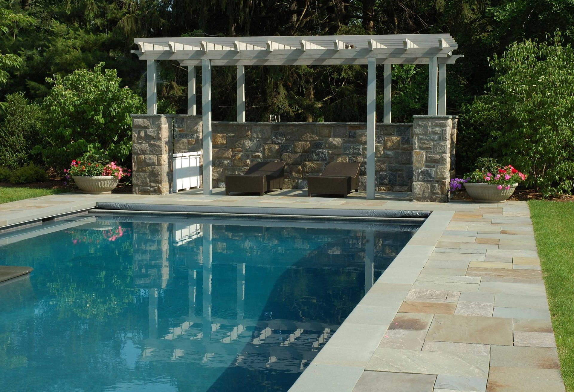 A large swimming pool with a pergola over it