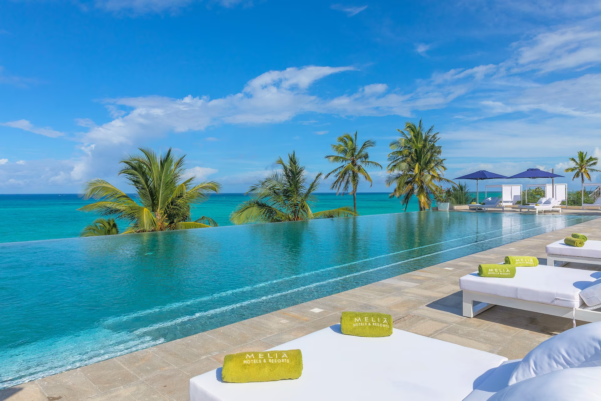 There is a swimming pool with a view of the ocean.