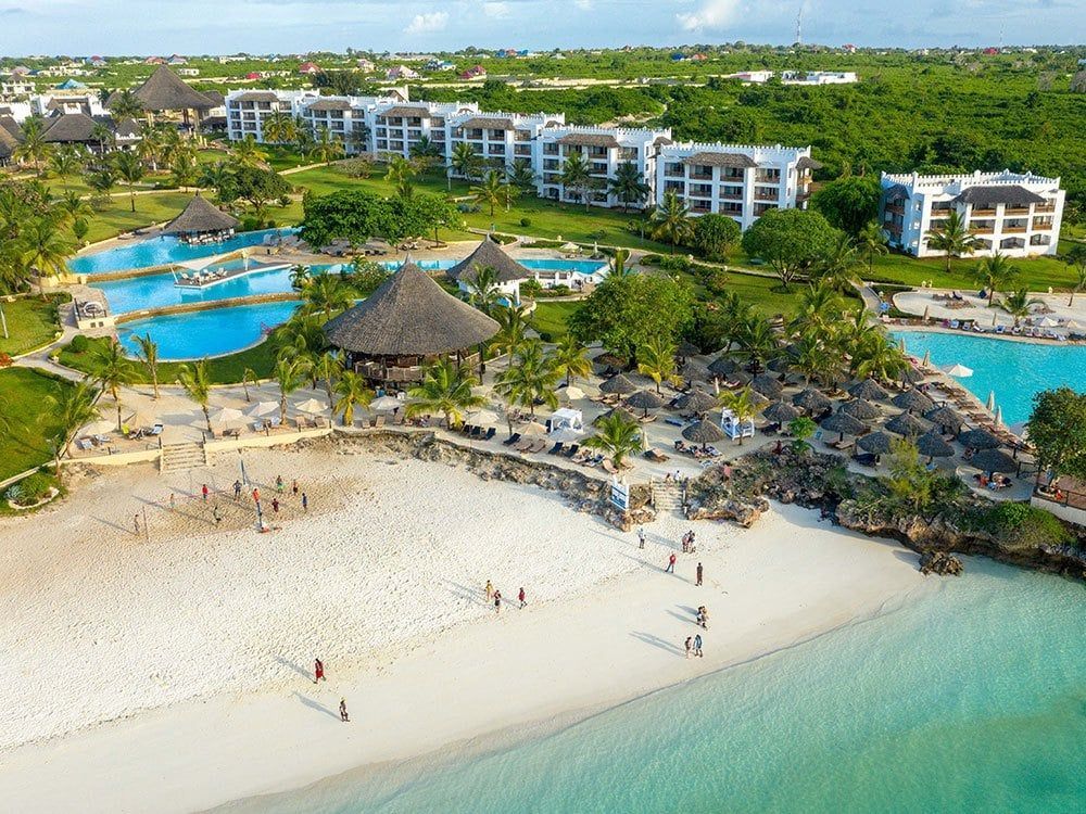 An aerial view of a resort with a beach and swimming pools