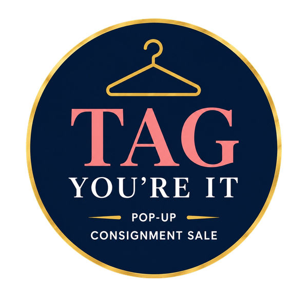 Dark blue circular logo with gold hanger and pink and white text: “TAG You’re It” pop-up consignment sale