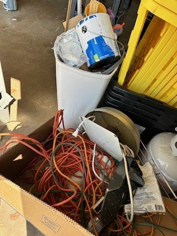 A box filled with junk and a bucket of paint.