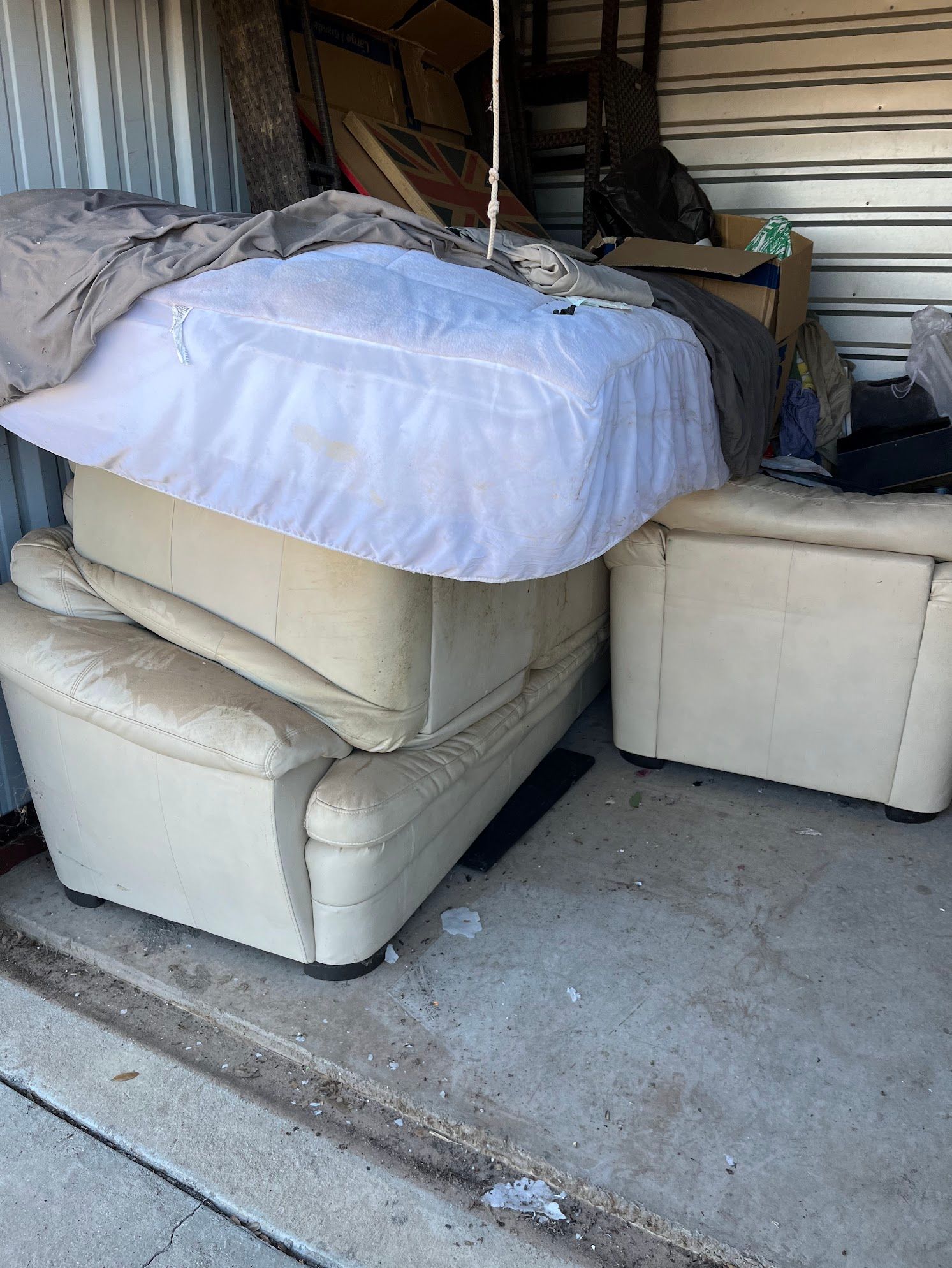 A pile of furniture is stacked on top of each other in a storage unit.
