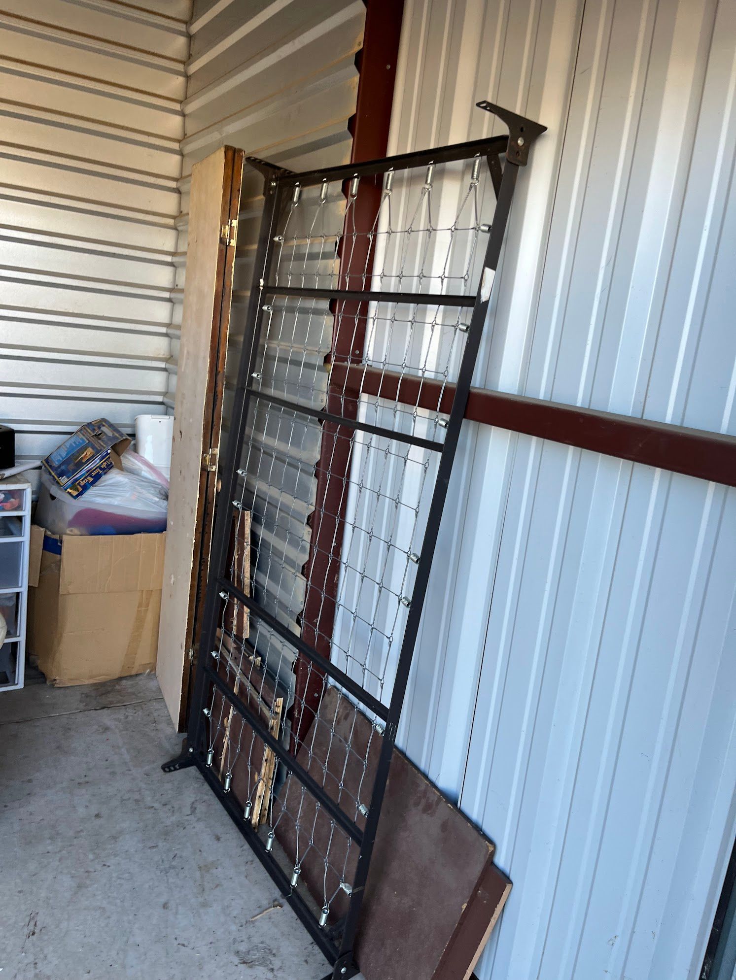 A metal fence is sitting in a room with a white wall