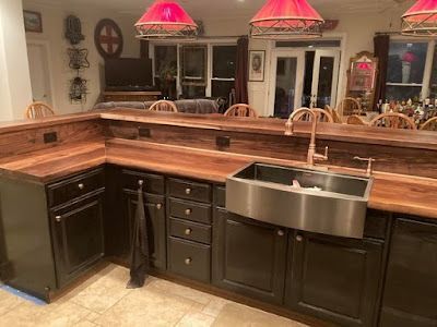 A kitchen with black cabinets and a stainless steel sink.