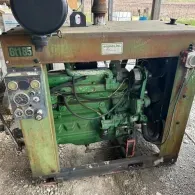 A green industrial John Deere engine mounted on a steel frame, featuring a control panel and air filter.