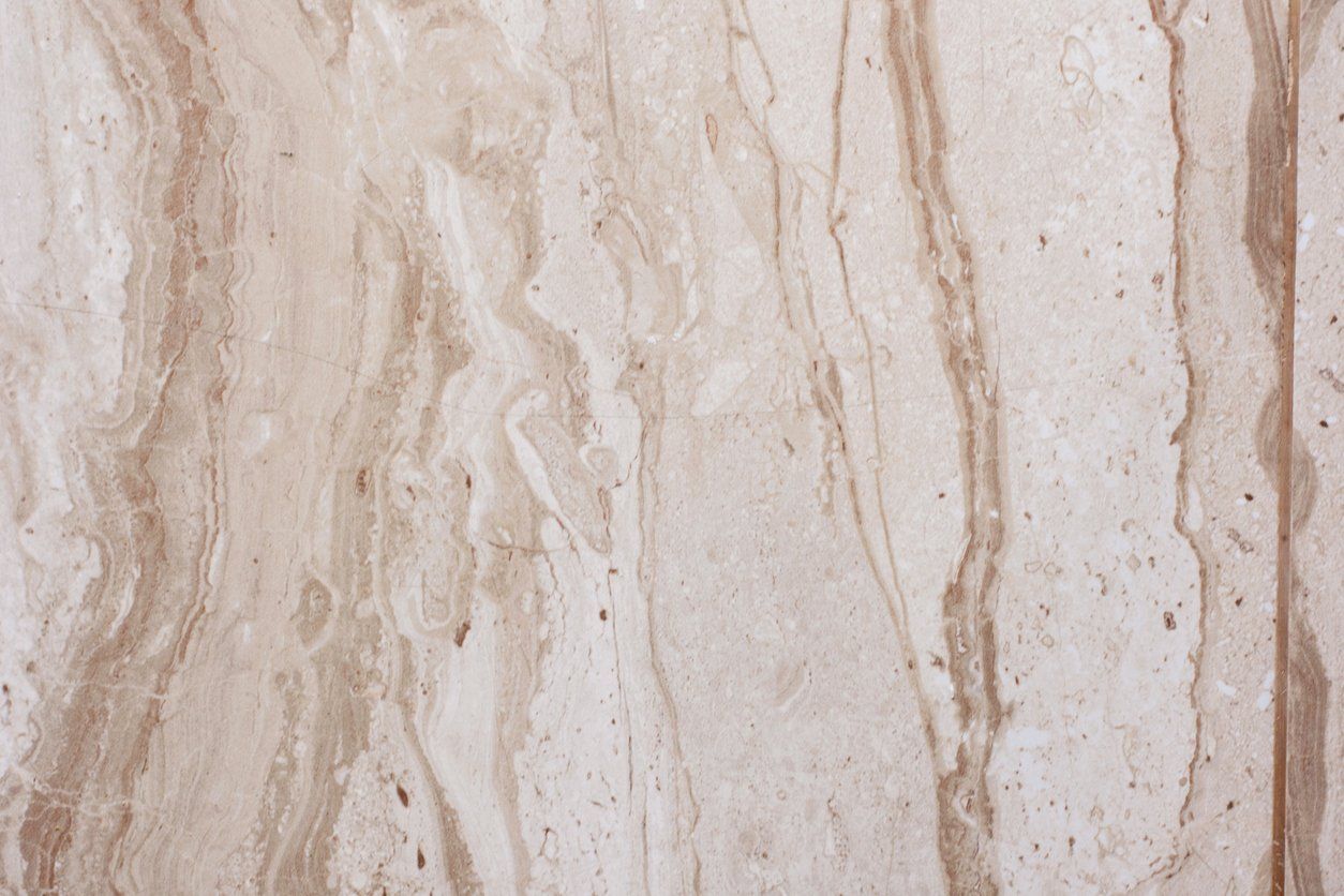 Light beige and brown marble surface with flowing, vertical veining.