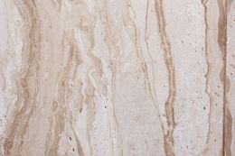 Tan and beige marble texture with flowing, vertical veining.