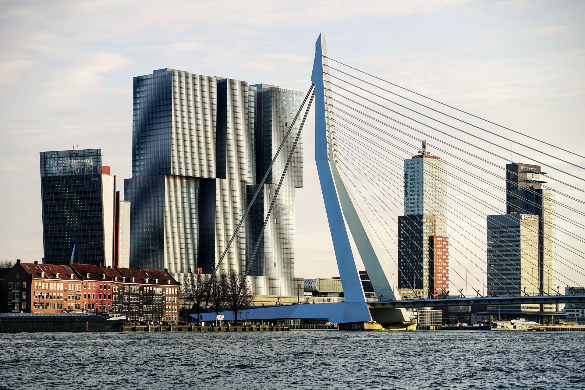 A bridge over a body of water with tall buildings in the background