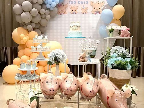 Party with pig theme decorations: balloons, cake, and pig-shaped balloons. Pastel colors.