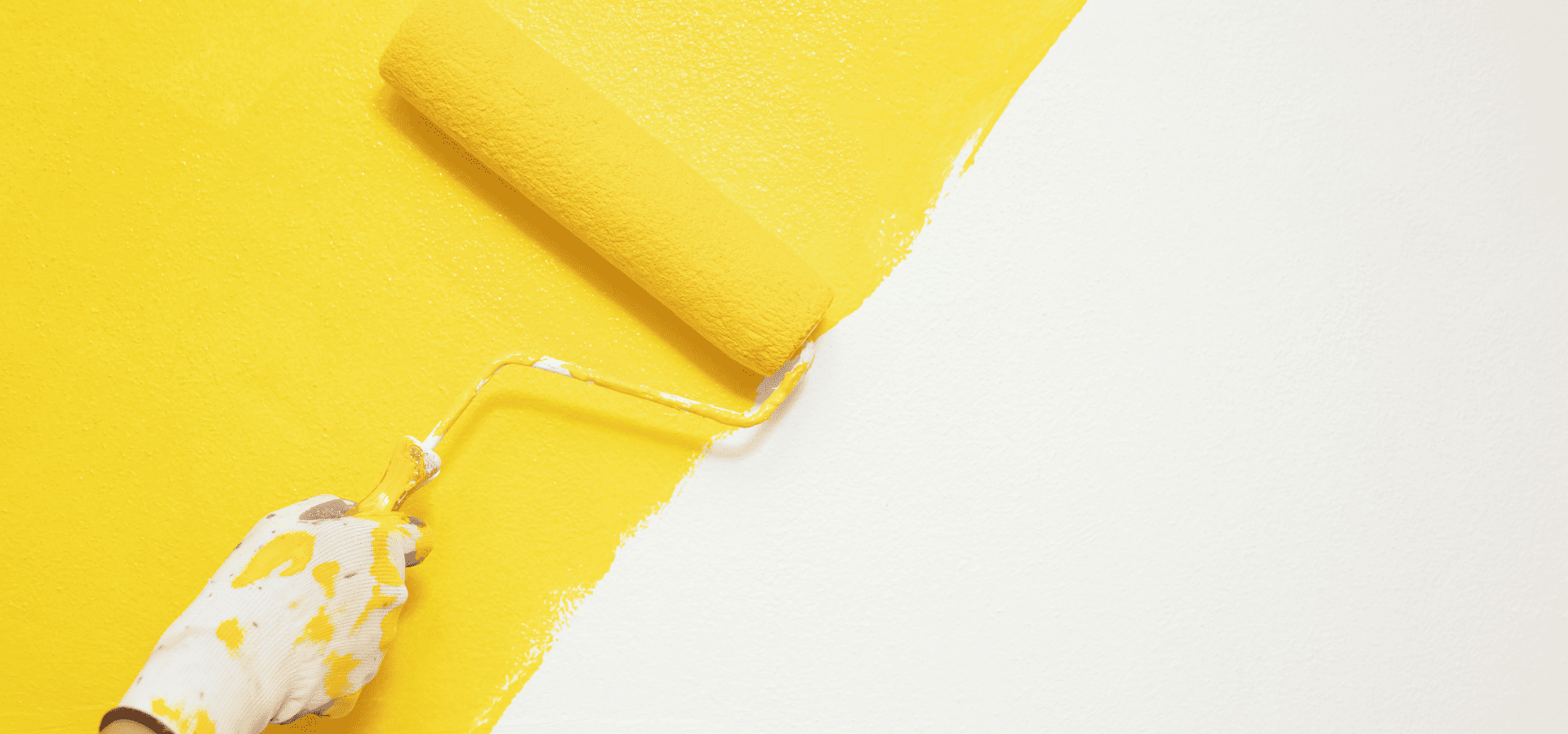 A homeowner painting his interior home walls yellow during winter