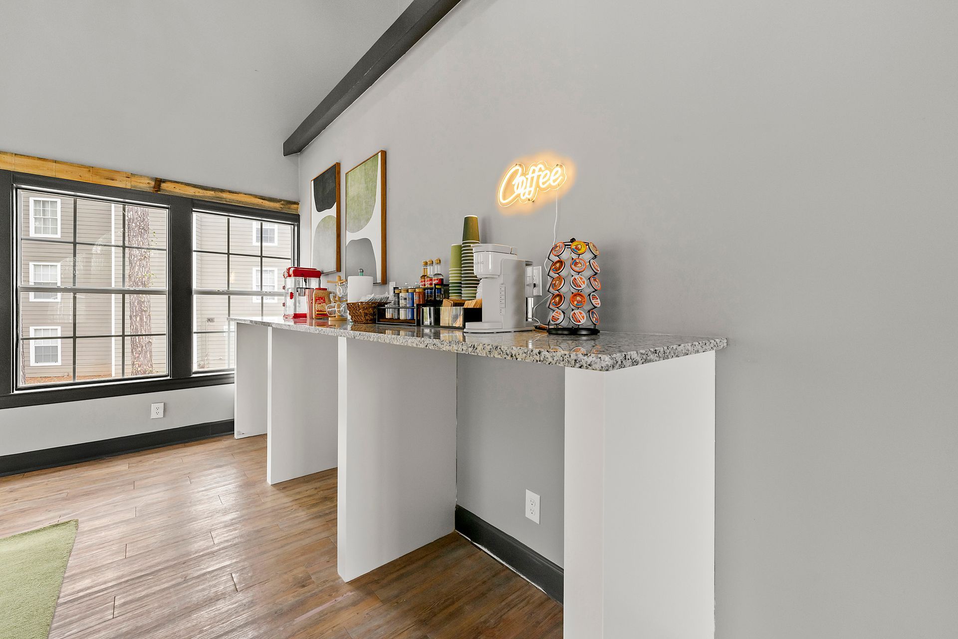 Modern kitchen bar area with white cabinets, granite countertop, and breakfast display by a window