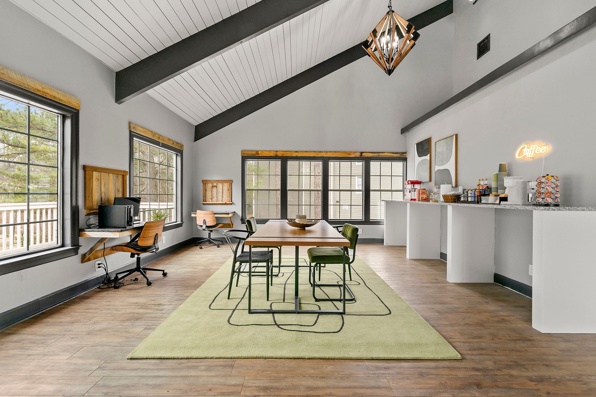 Bright modern loft office with exposed beams, desks, and a kitchen island in open space