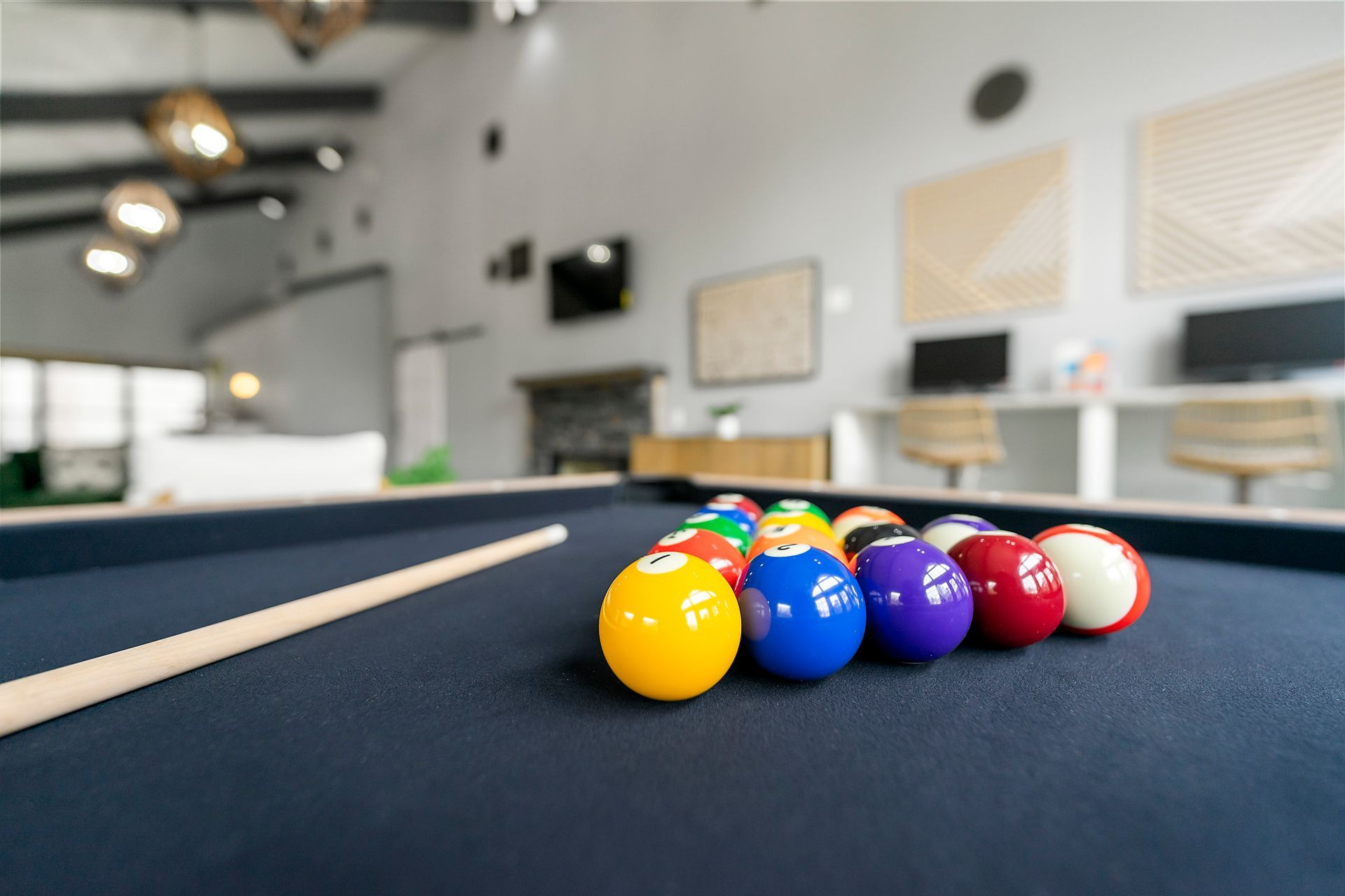 Pool table with colorful billiard balls clustered near the corner pocket in a modern room