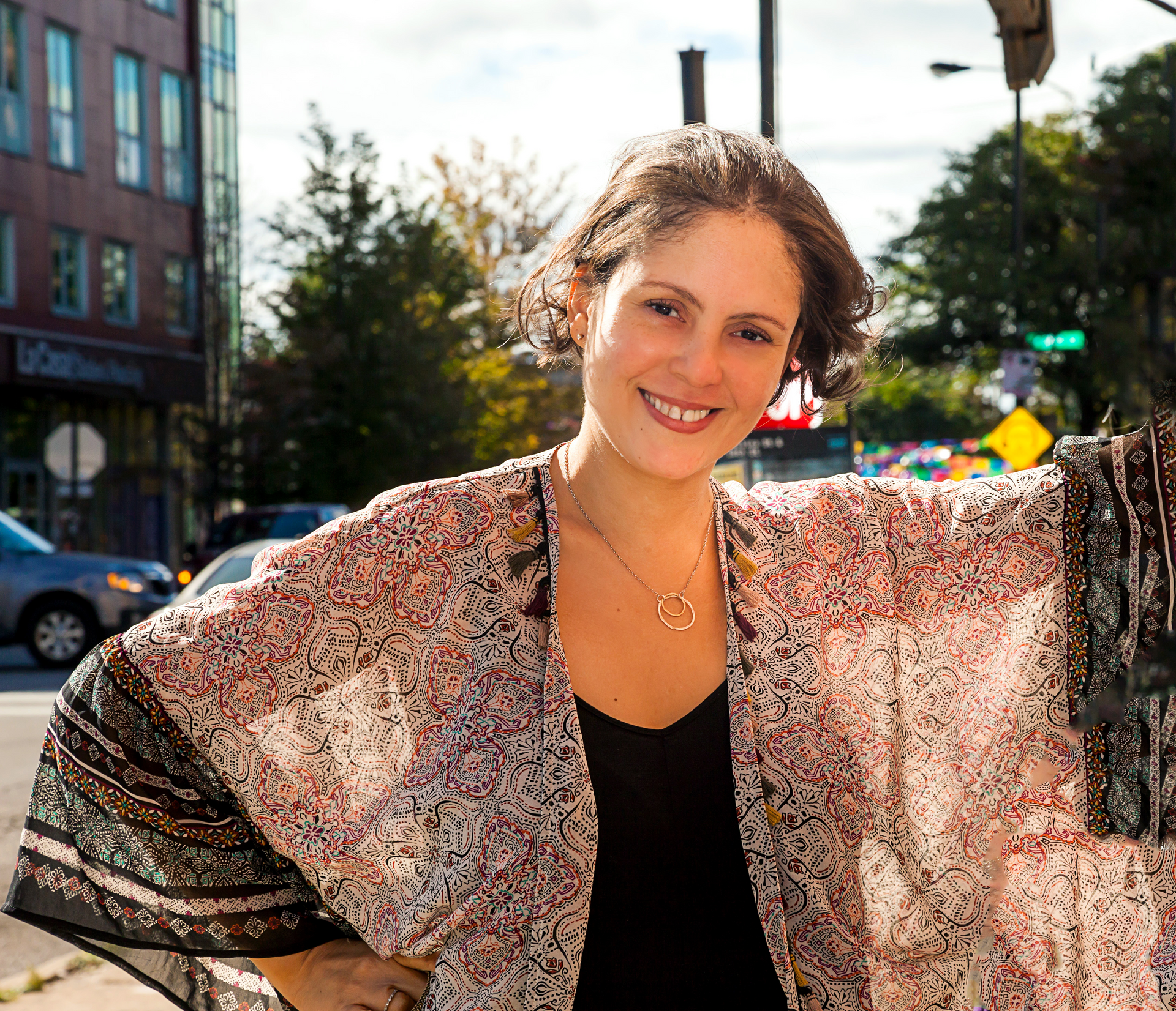 A smiling woman in a multicolored poncho
