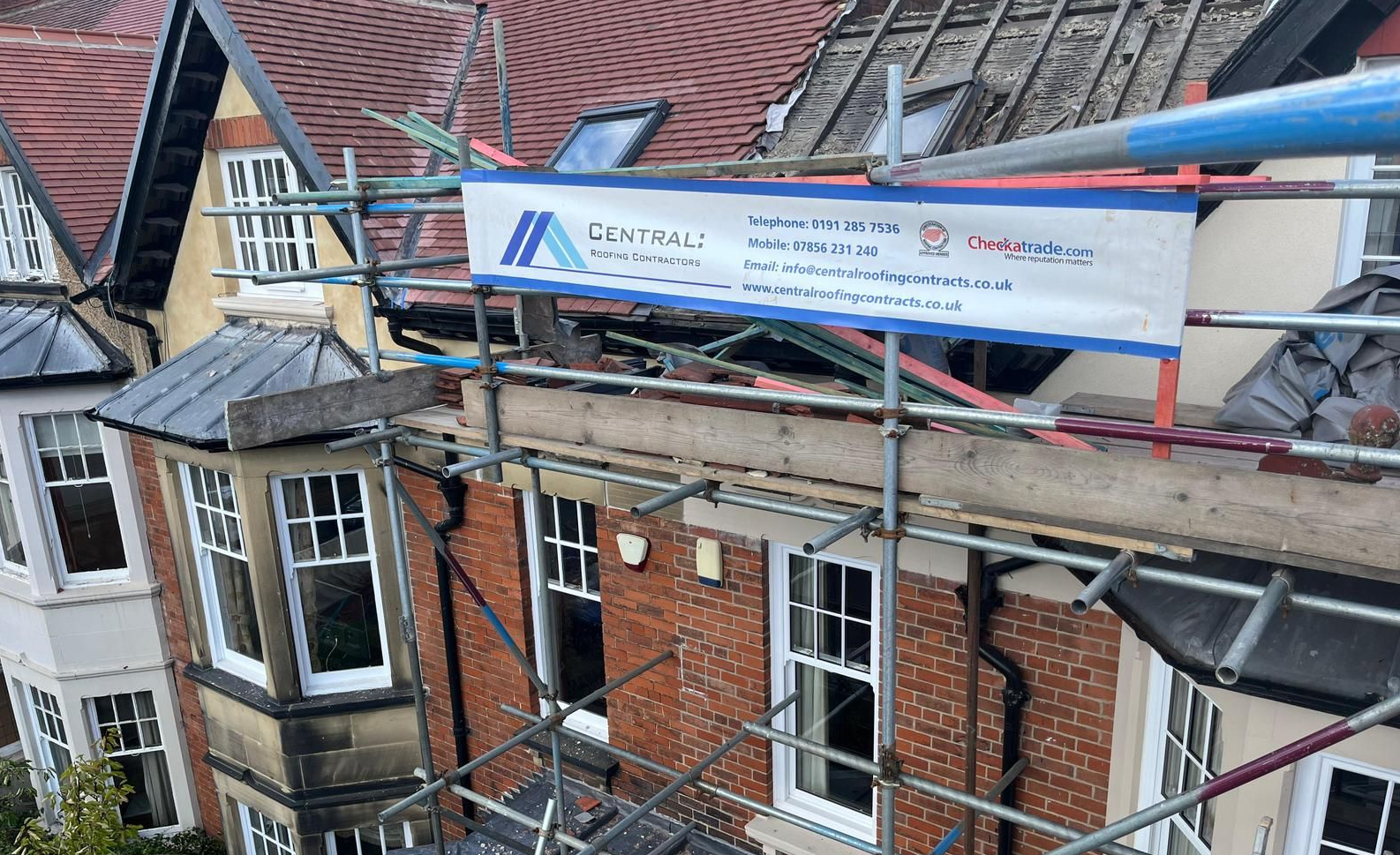 Scaffolding on a brick building with a banner for 