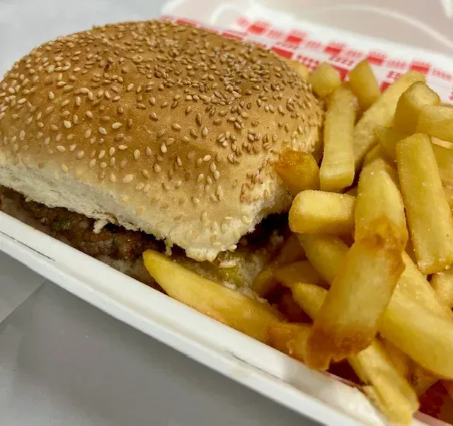 A Hamburger and French Fries in a Styrofoam Container — Cedar Park Fish & Chips In Taranganba, QLD