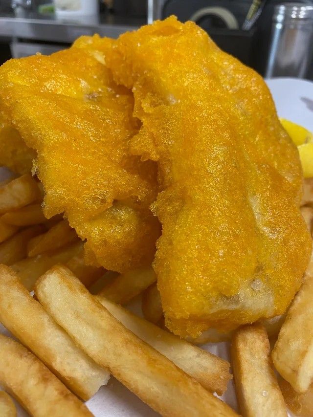 A Close Up of a Piece of Fish and French Fries on a Plate — Cedar Park Fish & Chips In Taranganba, QLD