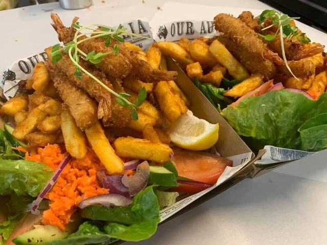 A Plate of Food With French Fries and Vegetables on a Table — Cedar Park Fish & Chips In Taranganba, QLD