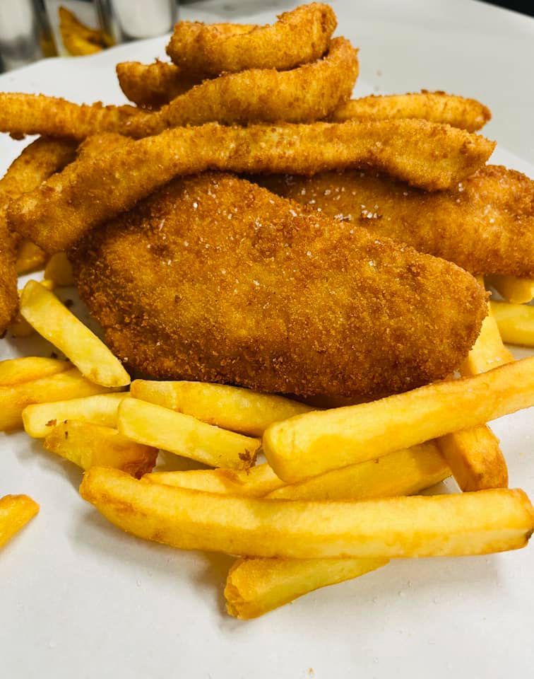 A White Plate Topped With French Fries And Fried Chicken — Cedar Park Fish & Chips In Taranganba, QLD
