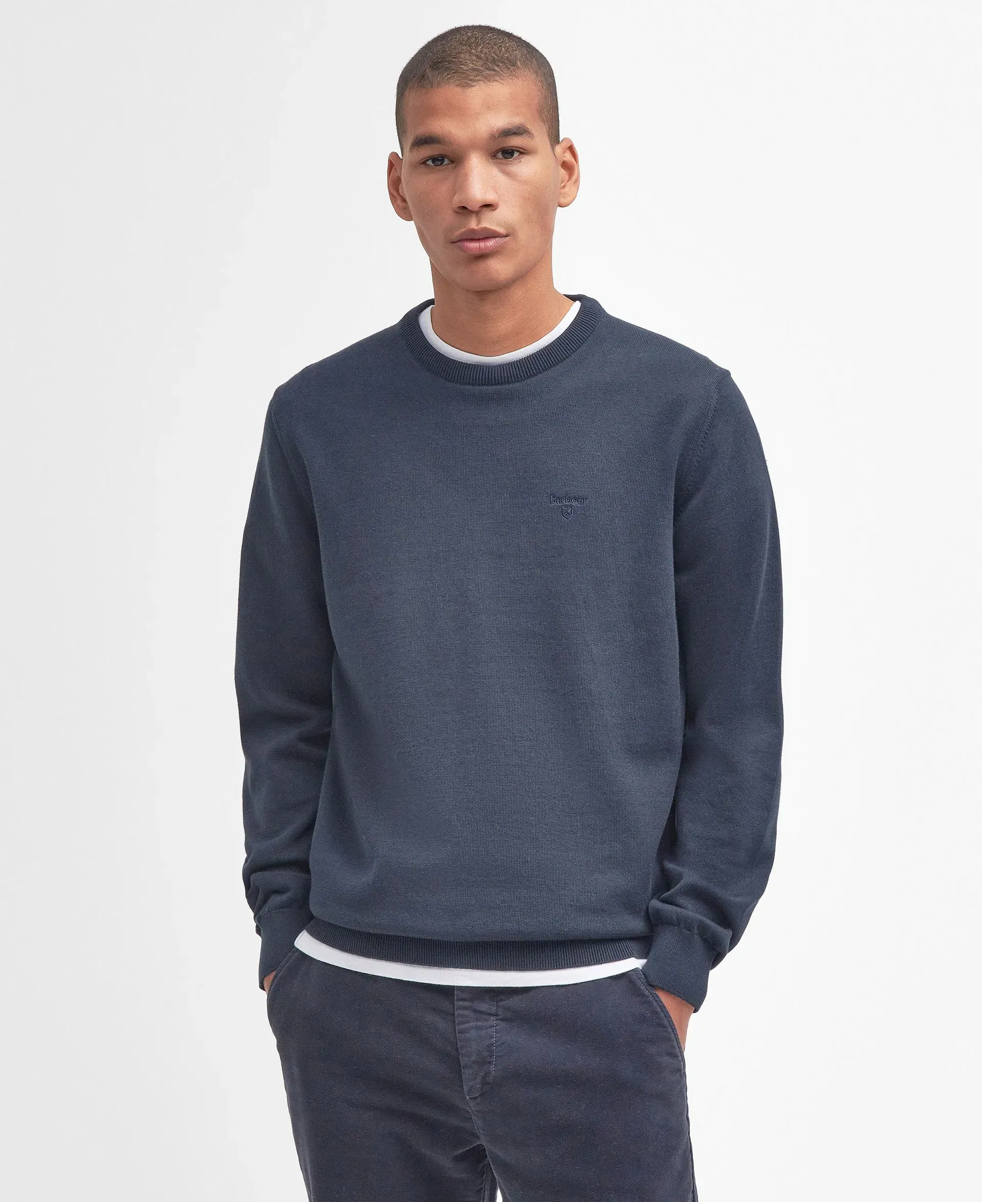 Un uomo che indossa un maglione blu e pantaloni blu