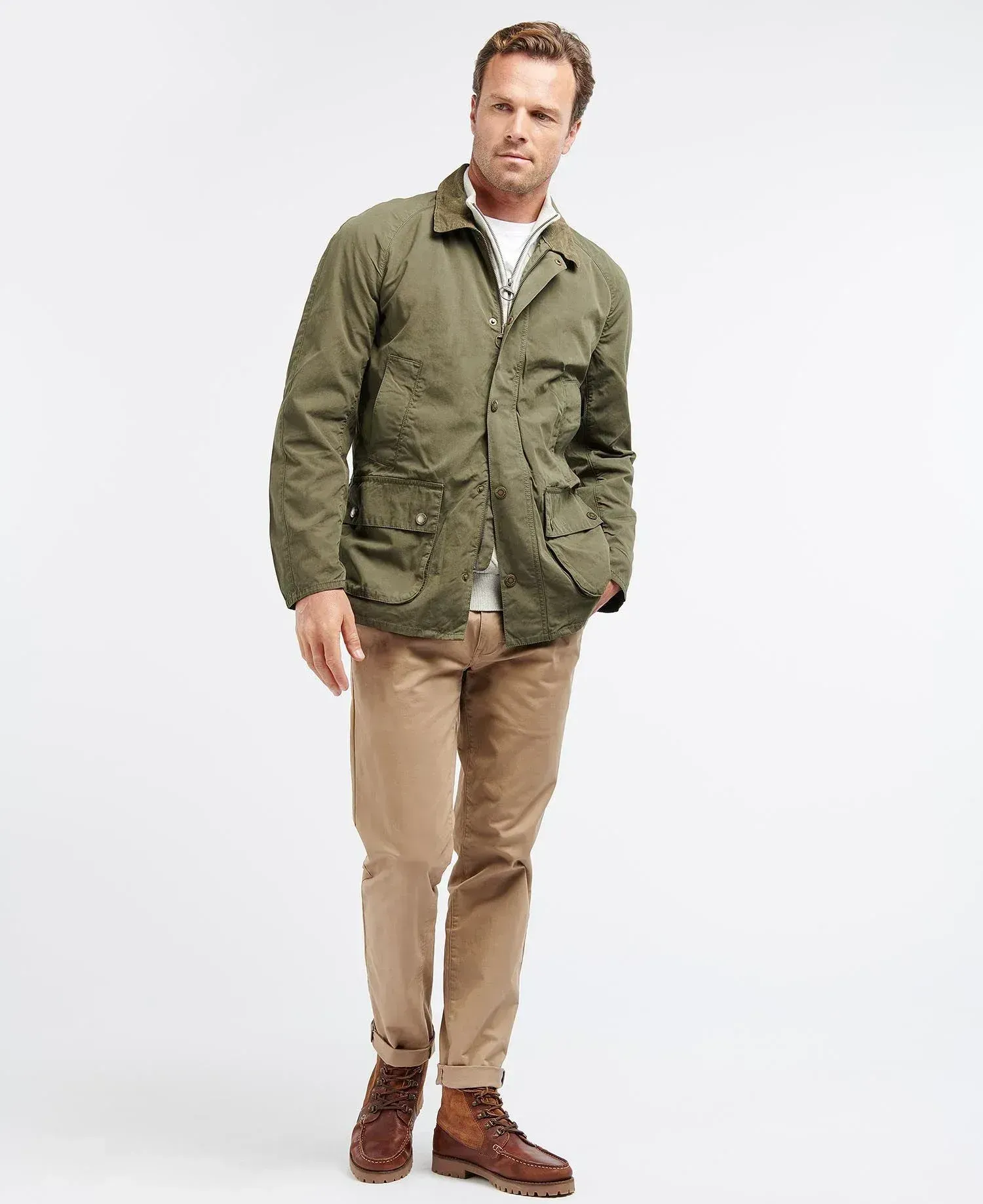 Un uomo indossa una giacca verde e pantaloni color cachi.