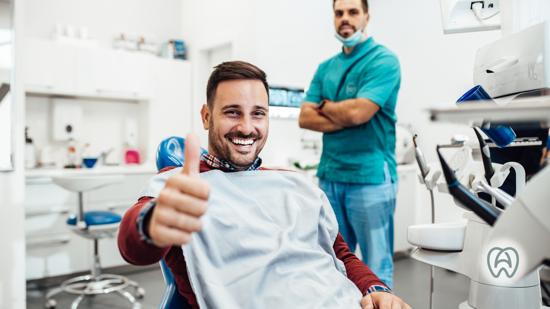 Smiling dental patient giving thumbs up in a bright clinic, with dentist standing behind him